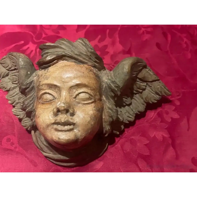 Ángel tallado en madera, detalle de rostro y alas Ángel tallado en madera, detalle de rostro y alas