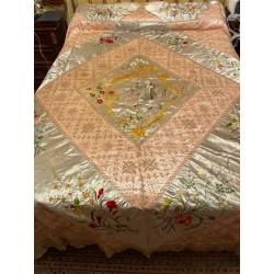 Colcha bordada a mano en seda rosa con motivos florales y pareja dieciochesca, trabajo filipino 1900
